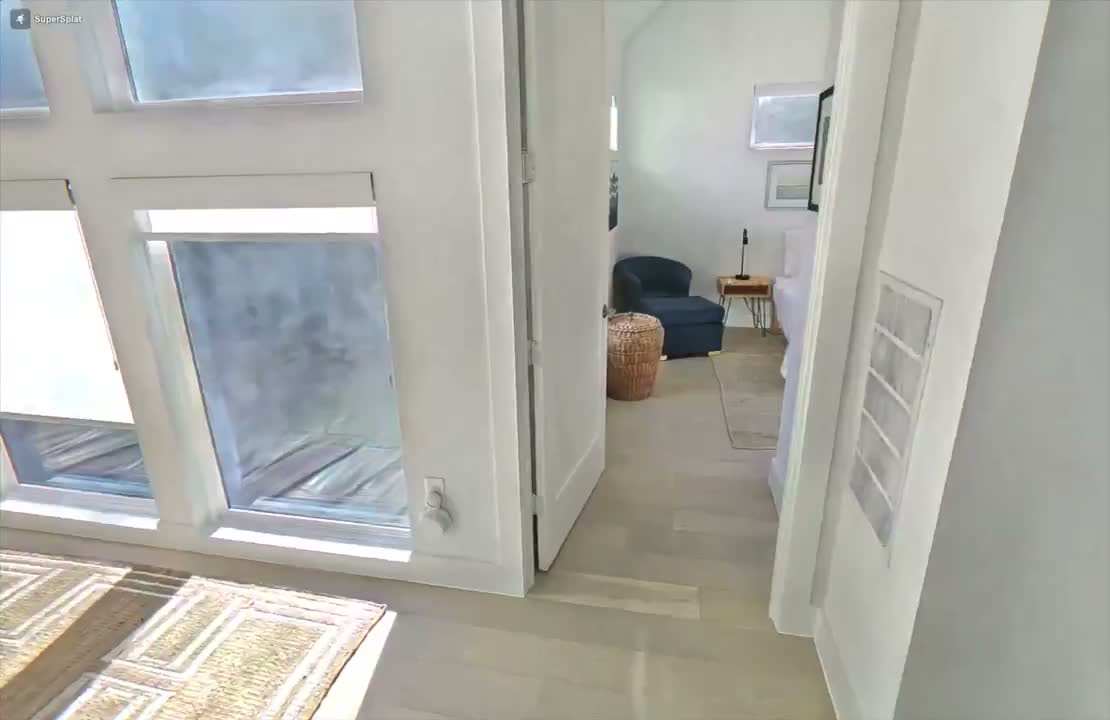 A Gaussian splat view of a room with a tall window on the left and a doorway through to a second room. The window itself has visible softness and slight distortions, characteristic of the splat algorithm struggling with transparent glass